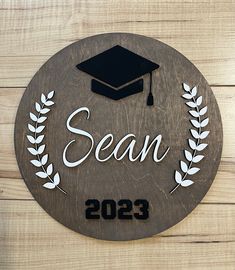 a wooden sign with a graduation cap and laurel around it that reads, dean 2093