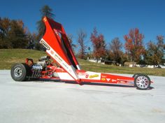 a red and white race car sitting on top of a parking lot