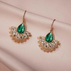 Make a statement with these stunning Art Deco Green Crystal Fan Dangle Earrings. The vibrant green crystals add a touch of elegance and glamour to any outfit. With their unique fan-shaped design, these earrings are a true statement piece. Handmade with attention to detail, they are made with high-quality materials to ensure durability and long-lasting beauty. Perfect for weddings, parties, or any special occasion, these earrings will make you feel like a true vintage diva. Add a touch of Art Dec May Birthstone Crystal Dangle Earrings For Party, Green Jeweled Crystal Earrings, Green Jeweled Crystal Drop Earrings, Green Dangle Crystal Earrings For Evening, Green Crystal Drop Earrings For Evening, Green Chandelier Earrings For Evening With Pierced Ears, Glamorous Green Crystal Earrings For Party, Glamorous Green Jeweled Earrings, Elegant Crystal Earrings For May Birthstone Party