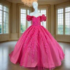 a pink ball gown is on display in a room with large windows and chandelier