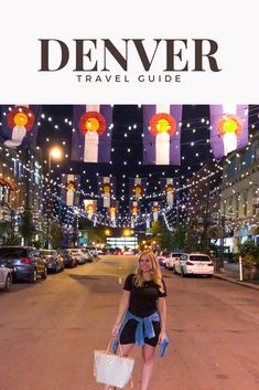 a woman is walking down the street with her shopping bag in hand and lights strung from the ceiling