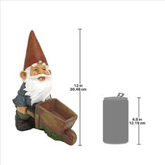 a garden gnome sitting on top of a piece of wood next to a metal can