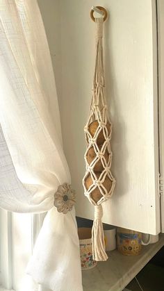 a white cabinet with a macrame hanging from it's side