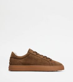 A sober and sophisticated taste characterizes these sneakers with minimal lines, with Tod's logo on the tongue. Crafted in soft suede, they come with a rubber outsole with embossed rubber pebbles. Brown Suede Low-top Sneakers, Classic Brown Suede Sneakers, Classic Suede Sneakers With Stitched Sole, Brown Suede Custom Sneakers With Textured Sole, Brown Suede Sneakers With Stitched Sole, Classic Suede Sneakers With Leather Sole, Casual Suede Sneakers With Leather Sole, Brown Lace-up Sneakers With Suede Lining, Suede Sneakers With Gum Sole And Plain Toe