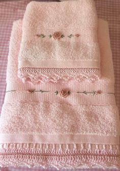 three pink towels are stacked on top of each other with lace trim around the edges