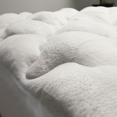 an unmade bed with white sheets and no sheets on the mattress top, close up