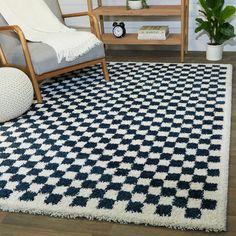 a living room area with a chair, rug and shelf on the floor in front of it