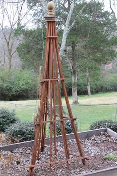 a tall wooden tower sitting in the middle of a garden