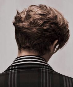 the back of a man's head with short, wavy hair in black and white