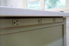 an electrical outlet on the side of a cabinet in a room with white walls and flooring