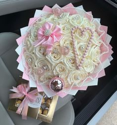 a bouquet in the back seat of a car decorated with pearls and pink ribbon bows