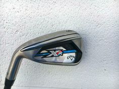 a close up of a golf iron on a white wall