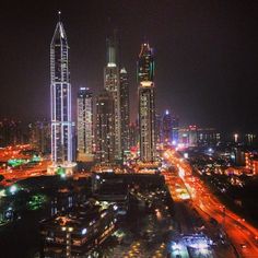 an aerial view of a city at night with lots of lights on the buildings and streets