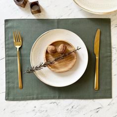 a plate with two nuts on it sitting next to a fork and knife, along with napkins