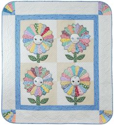 a quilted wall hanging with flowers and leaves on the front, in pastel colors