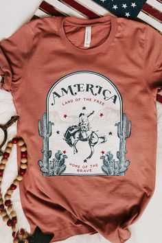 "🇺🇸 Land of The Free because of The Brave 🇺🇸 This shirt is high quality and super comfy!  This is definitely a shirt that you need to add to your wardrobe. Tag us in a photo of you wearing our shirt on Instagram @wildthreadsandco !  Please allow 2-3 days for printing 🌵CARE INSTRUCTIONS 🌵 For the longest lifespan for your Wild Threads + Co. shirt, we recommend turning your tee inside out, washing with cool water and hanging them to dry. We advise you to not use bleach. ⚡️ SIZING ⚡️ Measurem Women's Graphic Tees, Cute Country Outfits, Rodeo Shirts, Western Style Outfits, Fourth Of July Shirts, Patriotic Shirt, Vinyl Shirts, Country Shirts, Land Of The Free