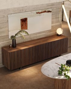 a wooden cabinet sitting next to a table with a potted plant on top of it