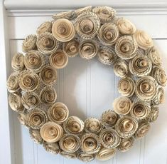 a wreath made out of rolled up books is hanging on the front door with a wooden handle