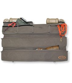 Keep all your gear securely behind your truck or SUV seat. This roomy organizer is perfect for hunting gear, dog-training accessories, fishing equipment and much more. Durable nylon/polyester pique blend. Includes: four large accessory pockets. And two padded gun cases that accommodate shotguns up to 48 inches long. Bottom gun case is detachable so you can use it as a field gun case. Bungee for attaching to seat included. Imported. | Truck Seat Gun Case Organizer, Nylon Truck Seat Organizer, Hunting Storage, Truck Storage, Gear List, Gear Organizer, Hunting Gear, Fishing Equipment, Fishing Gear, Cool Trucks