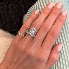 a woman's hand with two rings on her fingers and one ring in the middle