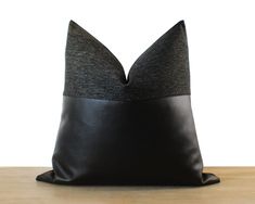 a black and grey pillow sitting on top of a wooden table