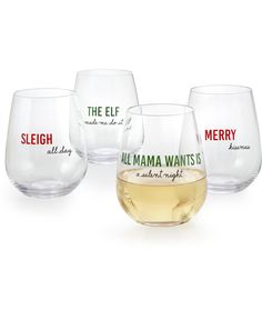 four wine glasses with labels on them sitting next to each other