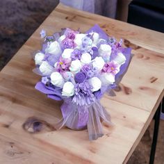 a bouquet of flowers sitting on top of a wooden table