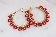 Add a touch of whimsical charm to your spring and summer wardrobe with these beautiful hand-beaded gold filled hoop earrings. Each earring is meticulously beaded with delica seed beads in a delightful flower pattern resembling daisies, making them perfect for a fun and playful look. The vibrant red hues add a pop of color to any outfit, making these earrings a must-have accessory for the season. Stand out in style with these charming and unique hoop earrings that are sure to brighten up your day.✔️handmade in the USA✔️lightweight & comfortable ✔️gold filled hoops✔️1.25 inches long & 1.5 inches wide✔️ships boxed and ready to gift in 3-5 business days with care instructions✔️30 day return policySHIPPING-3-5 business days as each of our pieces are created by hand at the time of order. If you Bohemian Beaded 14k Gold Filled Earrings, Handmade 14k Gold Filled Round Beaded Earrings, Handmade Adjustable Beaded Earrings In 14k Gold Filled, Handmade Adjustable 14k Gold Filled Beaded Earrings, Beaded 14k Gold Filled Hoop Earrings, Gold Hoop Earrings With Tiny Beads For Summer, Handmade Hoop Flower Earrings For Summer, Handmade Summer Flower Hoop Earrings, Hoop Earrings Diy