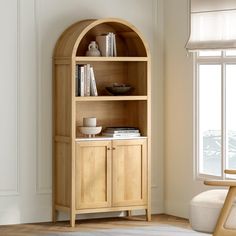 a wooden book shelf with books on top of it next to a chair and window