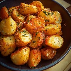 a close up of a plate of food with potatoes and seasoning on the side