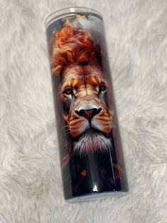 a glass with an image of a lion on it's face is sitting on a white surface