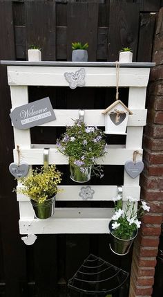 an old pallet is used as a planter for hanging flowers and other plants