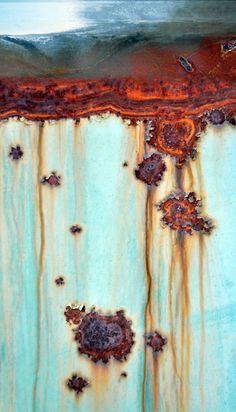 an abstract painting with rusted metal and blue paint on the bottom part of it