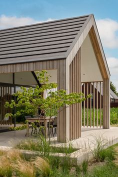 a small wooden house sitting on top of a lush green field next to tall grass