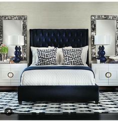 a large bed sitting next to two night stands on top of a black and white checkered floor