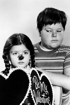 a boy and girl holding two heart shaped signs