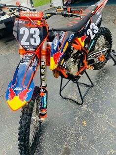 an orange and blue dirt bike parked in a parking lot