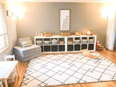 a living room filled with lots of furniture and storage containers on top of a rug