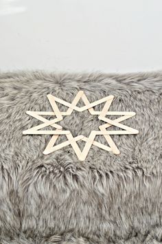 a wooden snowflake sitting on top of a furry surface