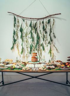 a table topped with lots of food next to a wall hanging from the ceiling above it