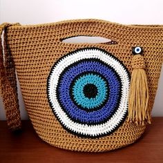 a crocheted bag with an evil eye on it