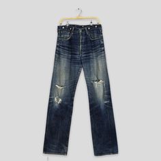 "Size 33x35 Vintage Levi's 702 LVC Redline Selvedge Jeans Faded Ripped Denim 90s Levi's Big E Japan Buckle Back Levi's Distressed Denim W33 Please contact me for any questions about this clothing before buying. SIZE MEASUREMENTS :- WAIST : 33\" inches HIPS : 44\" inches THIGH: 26\" inches  LEG OPENING : 17\" inches RISE : 12\" inches INSEAM : 35\" inches OUTSEAM (TOTAL LENGTH) : 46\" inches WEIGHT : 0.81 kg Condition : Distressed faded dirty jeans Good Vintage Conditions. Please pay close attent Vintage Jeans With Medium Wash And Frayed Hem, Vintage Medium Wash Jeans With Frayed Hem, Vintage Denim Blue Jeans With Frayed Hem, Vintage Denim Jeans With Frayed Hem, Vintage Full Length Flare Jeans For Streetwear, Vintage Faded Jeans With Frayed Hem, Retro Relaxed Fit Distressed Jeans, 90s Style Distressed Denim Blue Jeans, Vintage Jeans Medium Wash With Frayed Hem