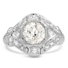 an antique style engagement ring with a large oval diamond center surrounded by smaller round diamonds