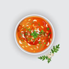 an overhead view of a bowl of tomato soup with herbs and parsley on the side