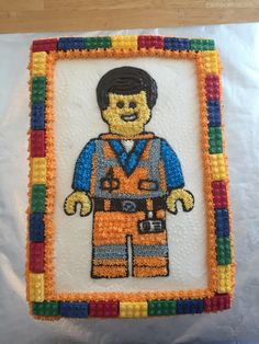 a lego man cake is decorated with multi - colored frosting