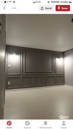 an empty room with wood paneling and lights on the wall, in front of a door