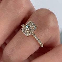 a woman's hand with a diamond ring on top of her finger and an engagement band