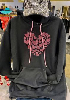 "Rhinestone hearts hoodie, Bling pink hearts hoodie, Valentines day hoodie, Hearts bling hoodie with bling drawstring Super cool rhinestone rose pink heart on black hoodie. We make the multi heart with rose pink rhinestones. They are super sparkly rhinestones, and so is the drawstring! The drawstring is rose pink also! Great Valentine's Day gift! This is a really pretty, pink heart. Pictures do not do it justice! We use high quality, multi-cut rhinestones for all our designs. These rhinestones a Black Hooded Sweatshirt Gift, Black Hooded Sweatshirt As Gift, Winter Hoodie With Rhinestones, Black Rhinestone Hoodie For Winter, Black Cotton Hoodie For Gift, Black Cotton Hoodie As Gift, Black Casual Hoodie As Gift, Black Casual Sweatshirt Gift, Casual Black Hoodie As Gift