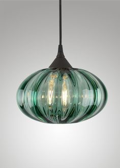 a green glass light hanging from a ceiling