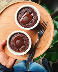 two chocolate desserts on a wooden plate with a fork